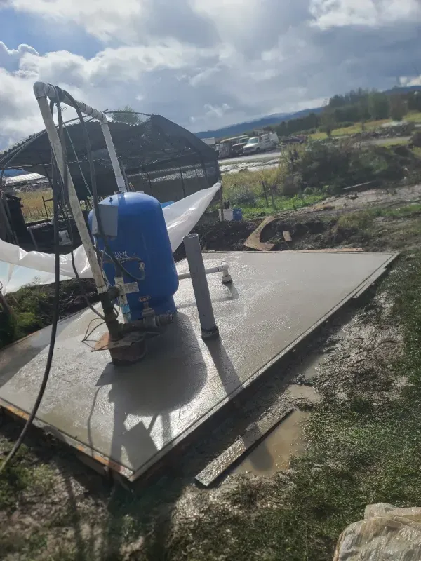 A blue tank is sitting on top of a concrete platform.