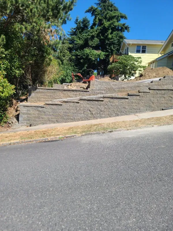 A brick wall is being built in front of a house.