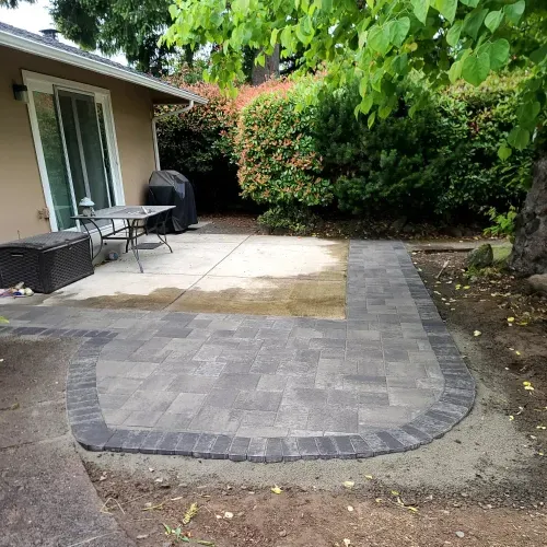 A patio with a table and chairs in front of a house.