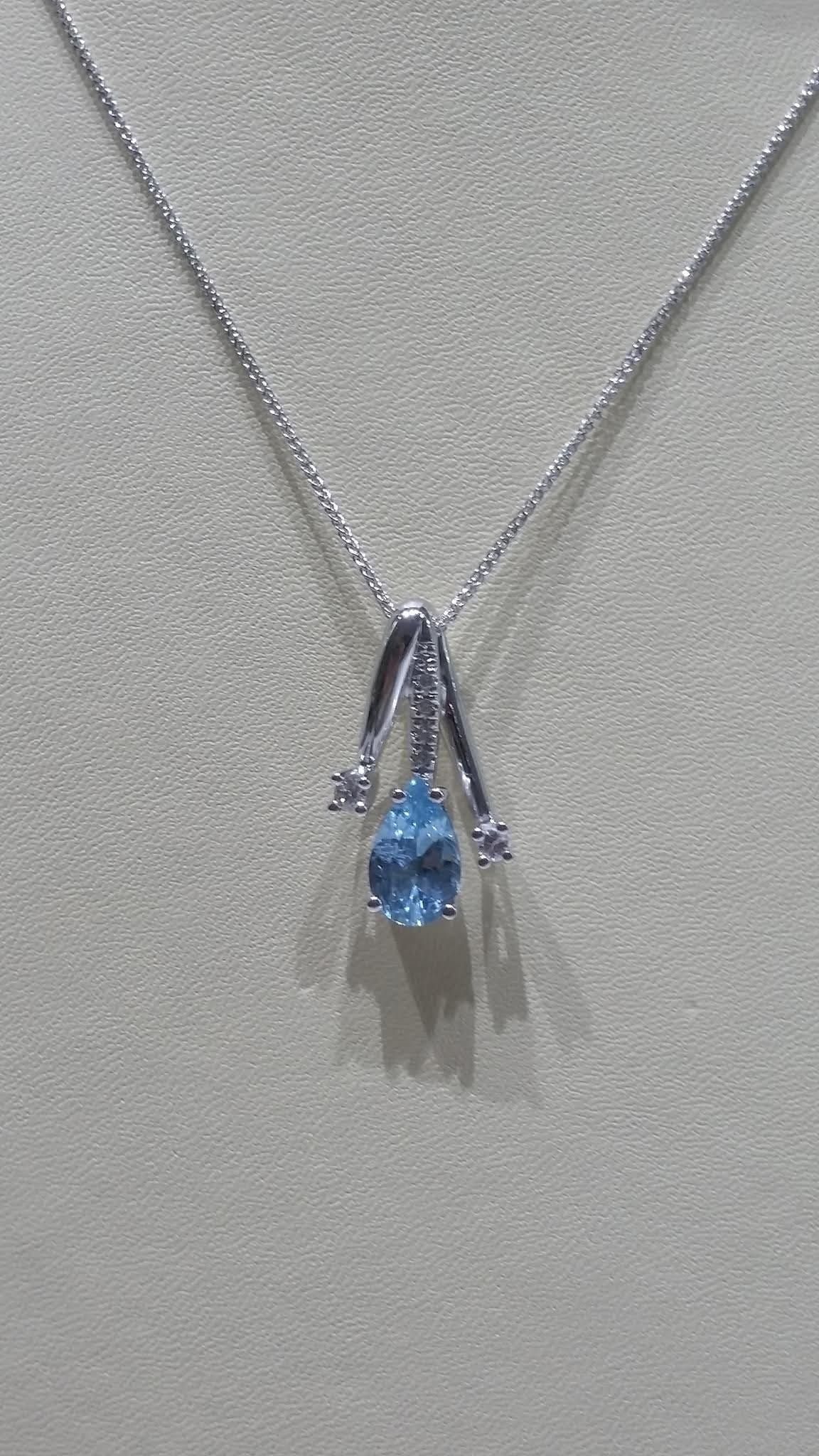 Collana in argento con pendente in pietra preziosa blu a forma di pera e due piccole pietre laterali.