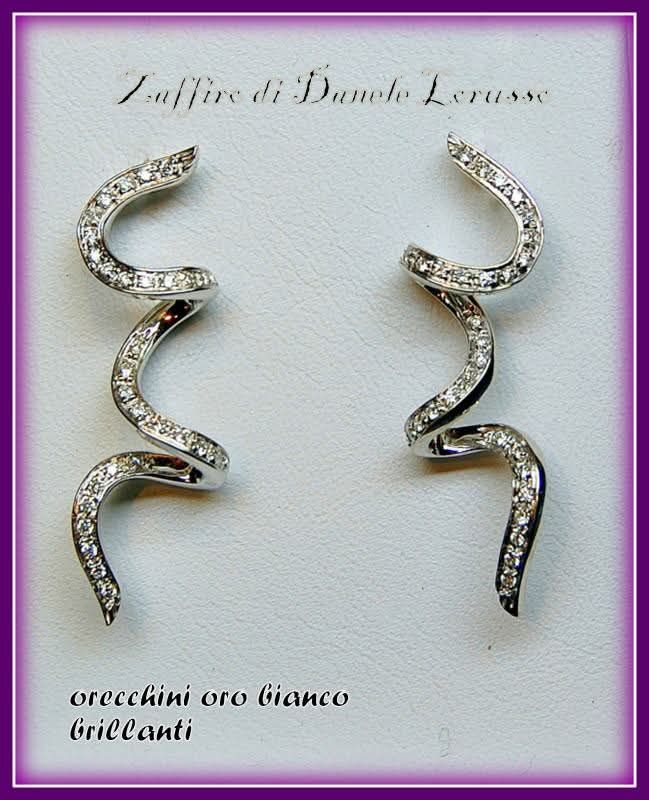 Orecchini in oro bianco e diamanti con design a spirale curva.