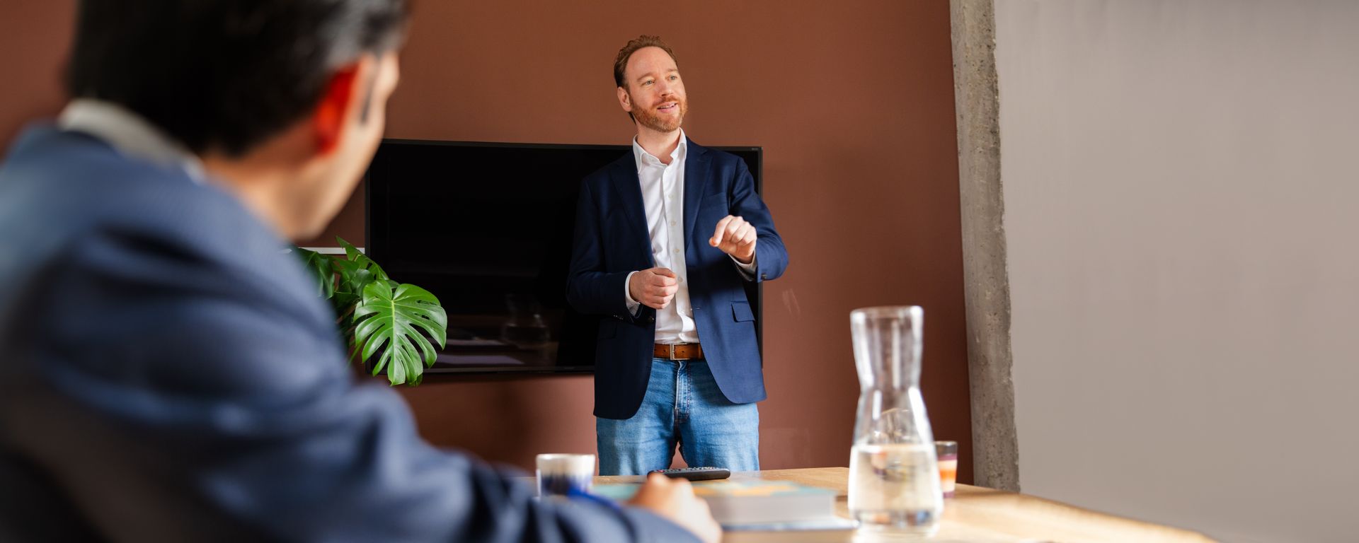 Een man geeft een presentatie aan het bestuur in een vergaderruimte.