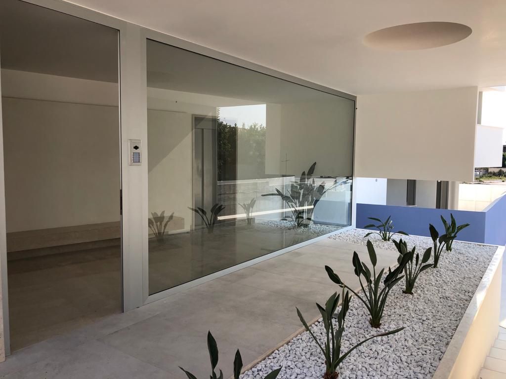 Un edificio con molte finestre e piante davanti