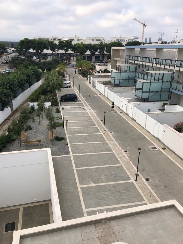 Una veduta aerea di un parcheggio con un edificio sullo sfondo