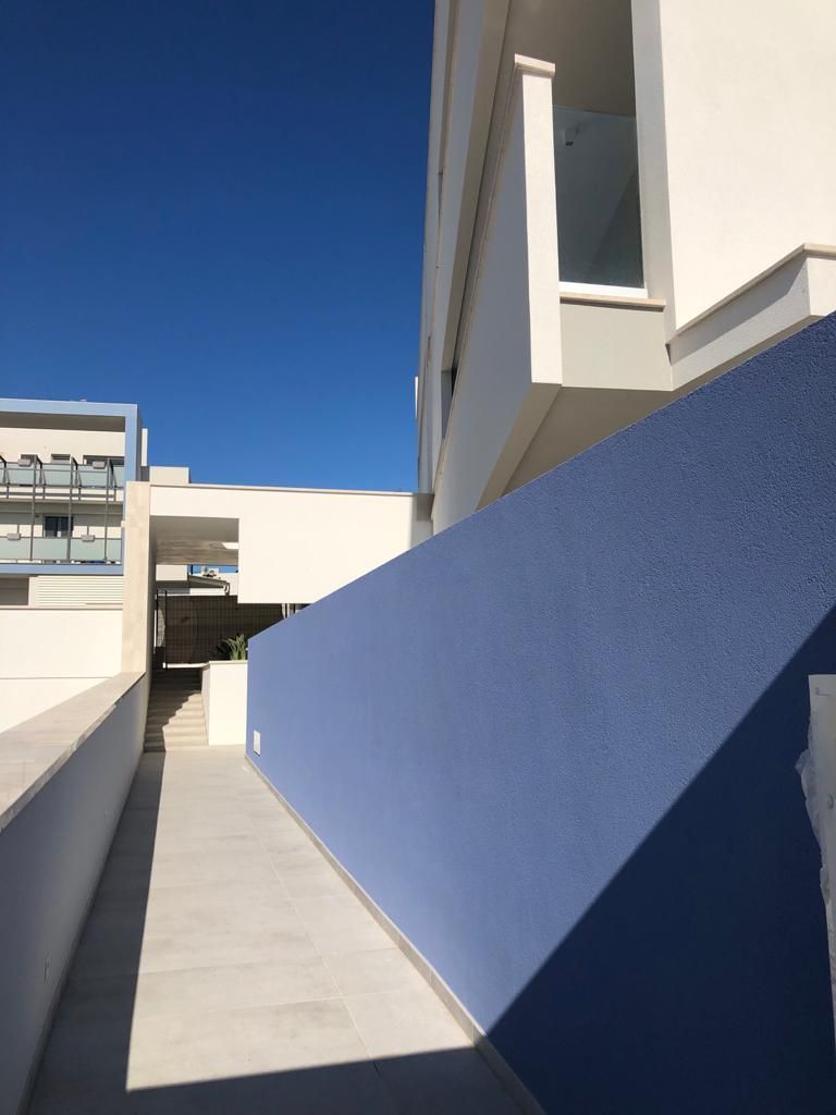 Un edificio con un muro blu e delle scale che vi conducono