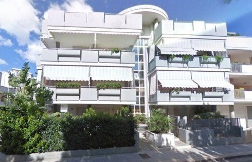 Un edificio con molti balconi e tende da sole