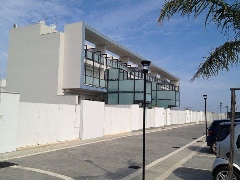 Un parcheggio con auto parcheggiate davanti a un edificio