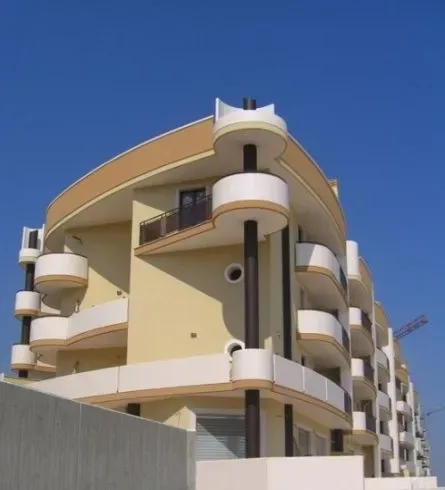Un grande edificio con tanti balconi e un cielo azzurro sullo sfondo
