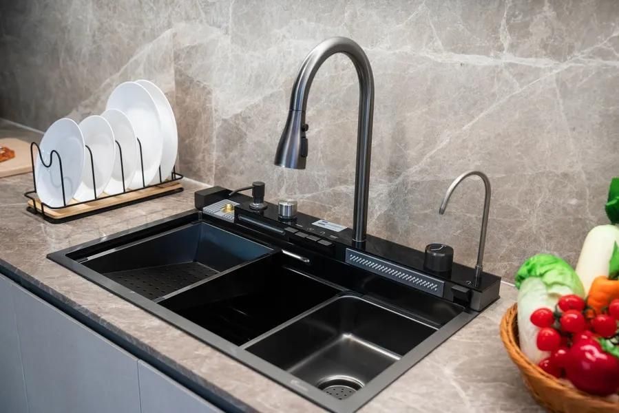 Black kitchen sink with faucet, a separate water filter, and plates drying nearby.