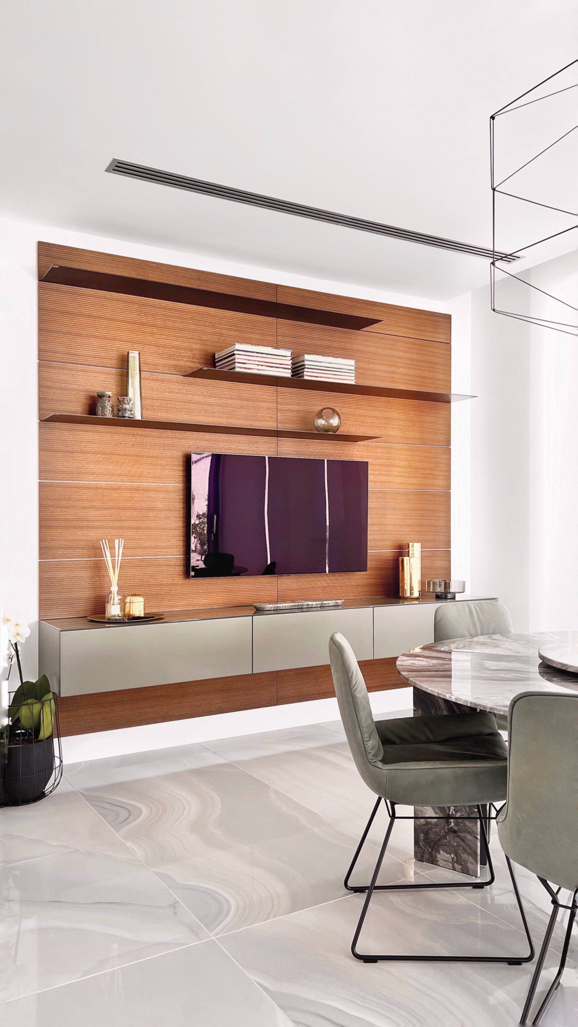 Living room: TV on a brick wall with shelves, modern dining table with green chairs, and marble floor.