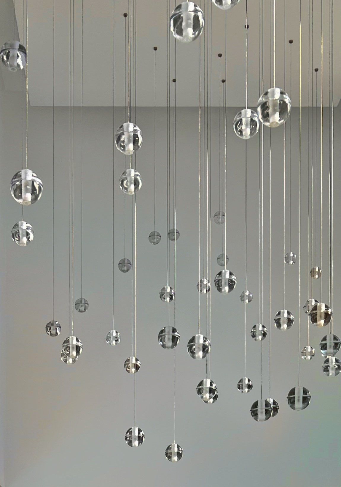 Crystal ball lights from Bocci, hanging from the ceiling in a modern space.