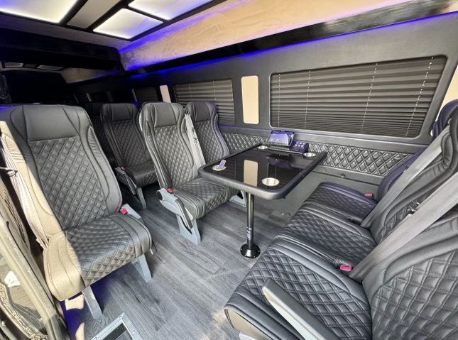 A chauffeur in a suit is opening the door of a car