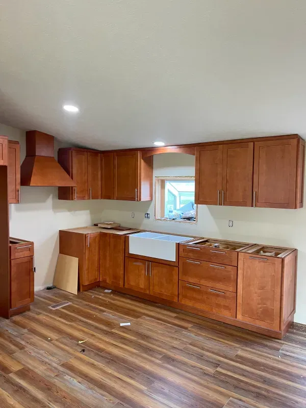 A kitchen with wooden cabinets and hardwood floors is being remodeled.