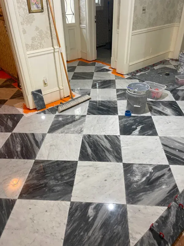 A black and white checkered floor with a mop and bucket on it.