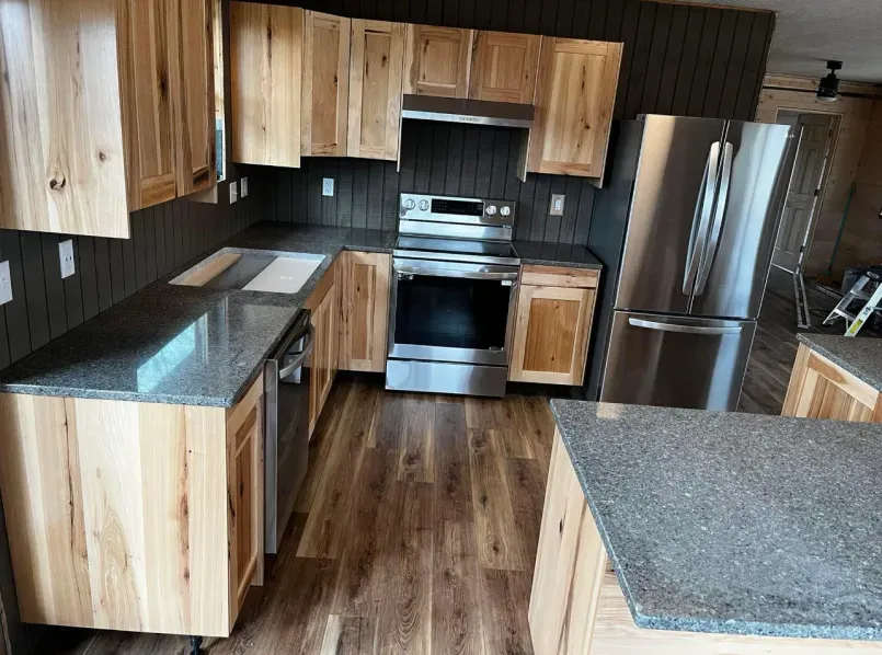 A kitchen with wooden cabinets stainless steel appliances and granite counter tops