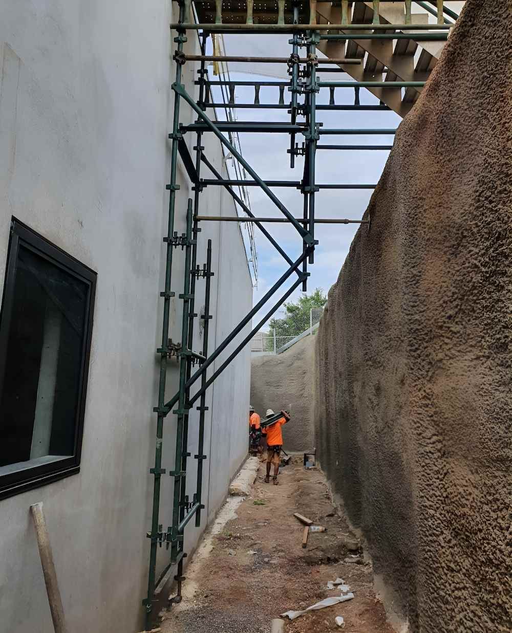 A Construction Site With Scaffolding on the Side of a Building — All Coast Scaffolding In Yandina, QLD