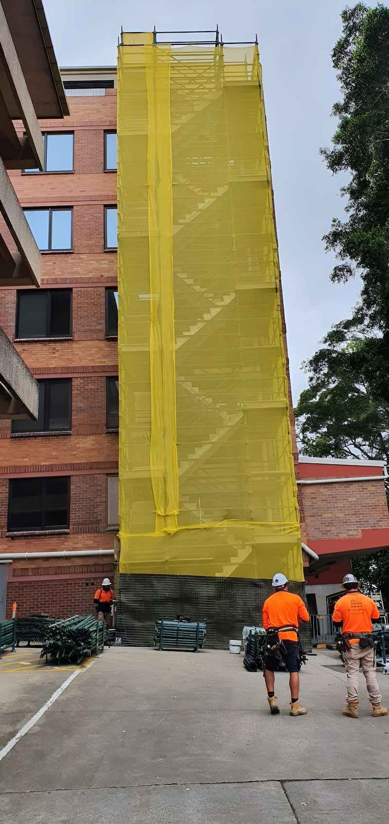 A Group of Construction Workers Are Walking Down a Street — All Coast Scaffolding In Yandina, QLD