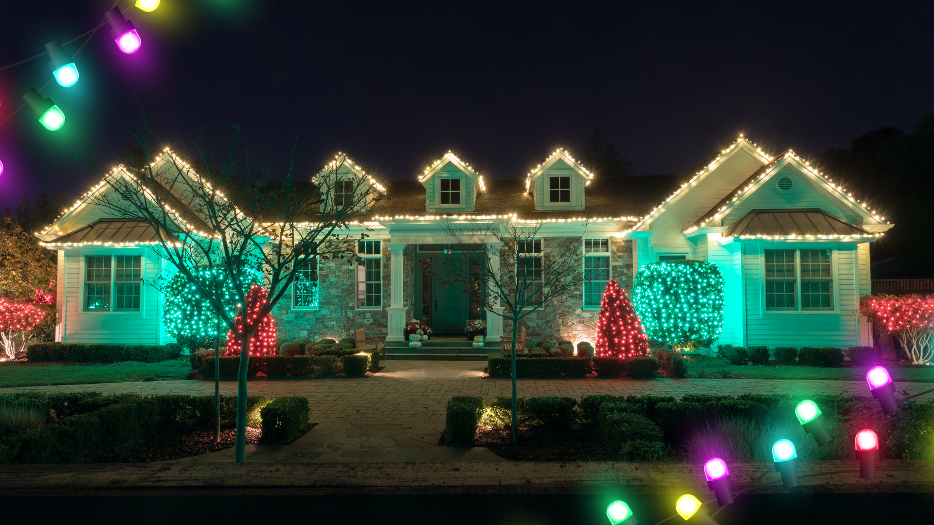 House decorated with colorful Christmas lights at night.