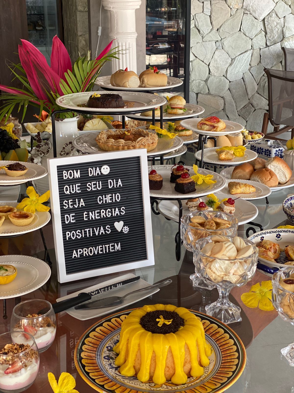 Buffet de café da manhã com doces, frutas e uma placa desejando um bom dia.Pousada Villa Italiana