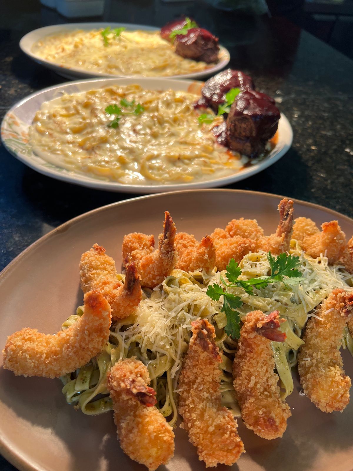 Três pratos de comida: macarrão com queijo e camarão frito.Pousada Villa Italiana