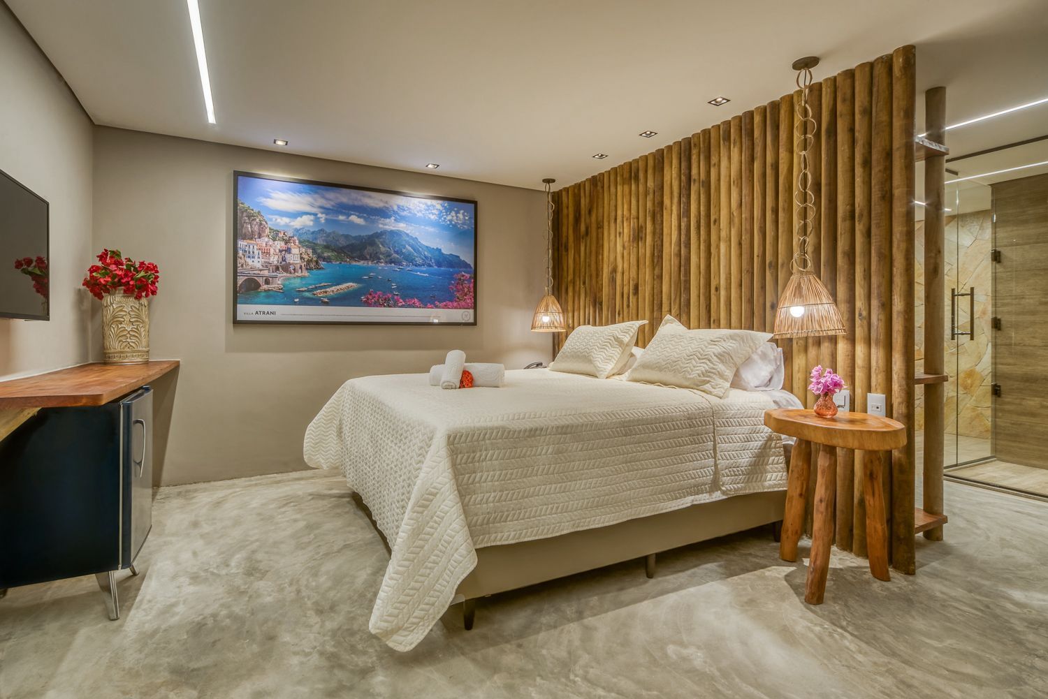 Quarto aconchegante com parede de madeira, cama king-size e arte emoldurada; inclui mesa lateral e banheiro adjacente.Pousada Villa Italiana