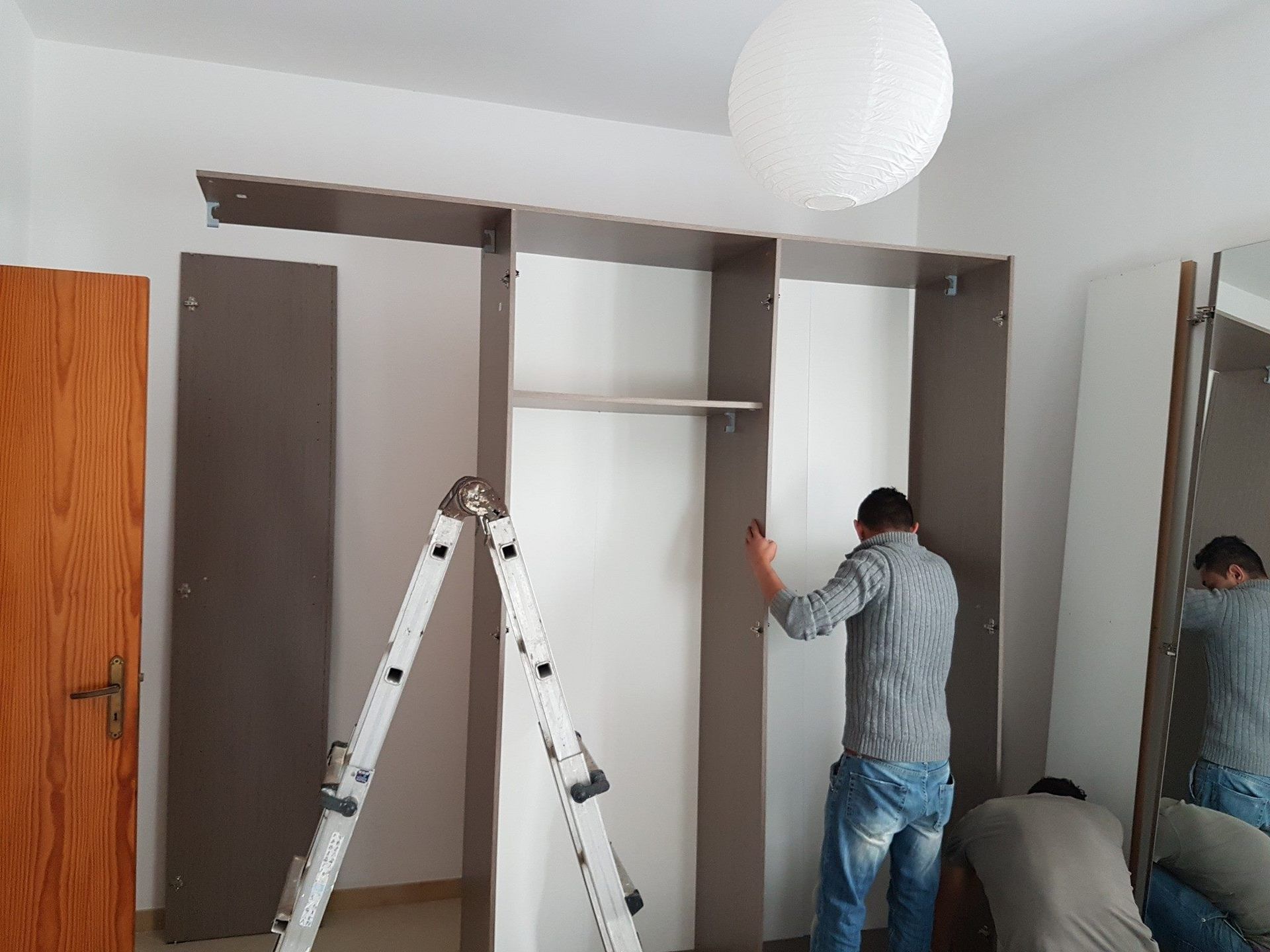 Operaio della ditta di traslochi monta un armadio