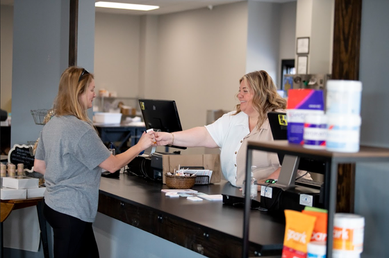 Two women are standing at a counter in a pharmacy.