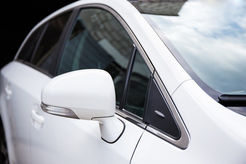 A Close Up of a White Car 's Side Mirror — Rod's Total Tint In Thornton, NSW