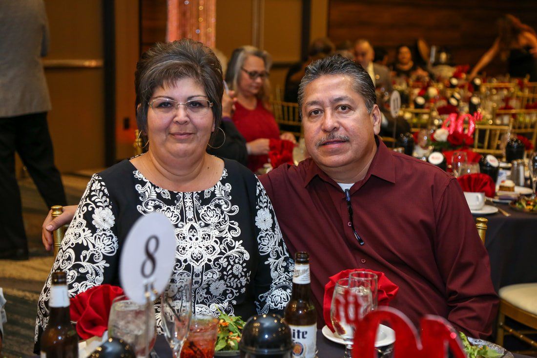 A man and a woman are sitting at a table with a number 8 on it.