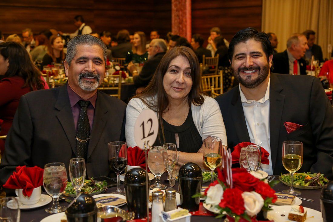 A group of people are posing for a picture at a dinner table.