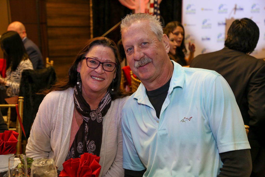 A man and a woman are posing for a picture at a party.