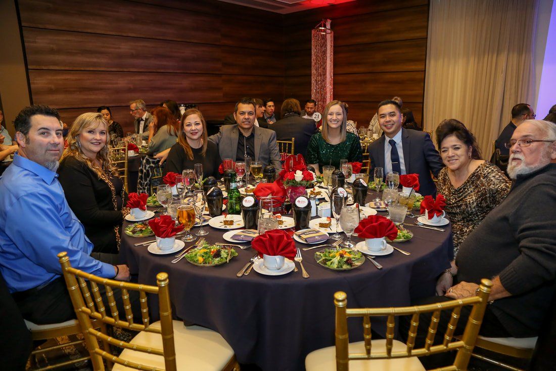 A group of people are sitting at a table with plates of food.