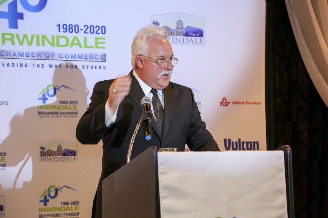 A man in a suit and tie is giving a speech at a podium