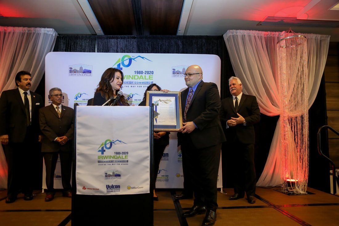 A man is giving a certificate to a woman at a podium.