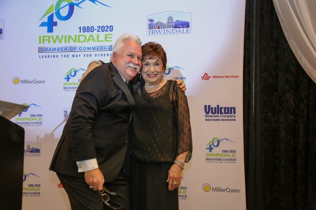 A man in a suit is hugging a woman in a black dress.