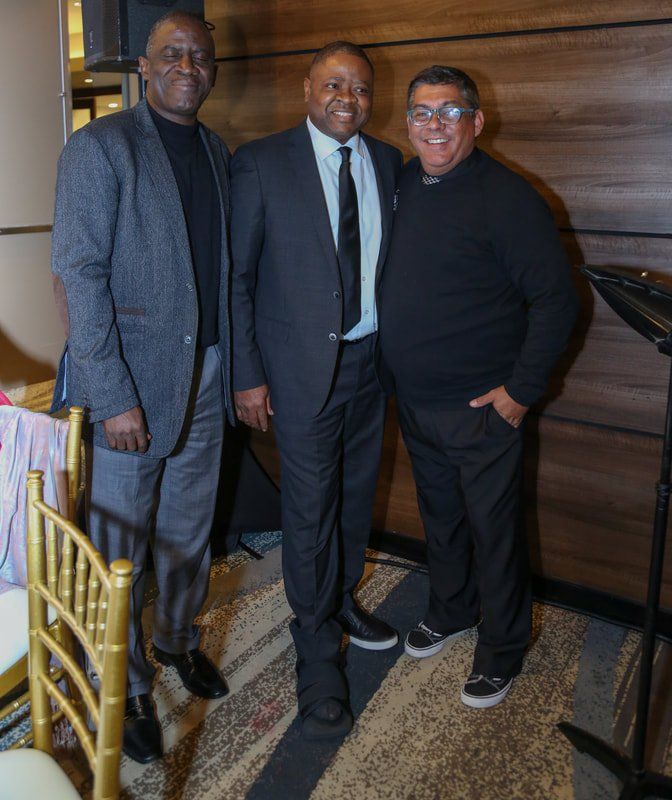 Three men in suits and ties are posing for a picture.