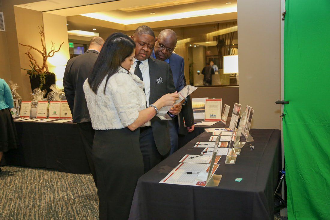 A group of people are standing around a table looking at a brochure.