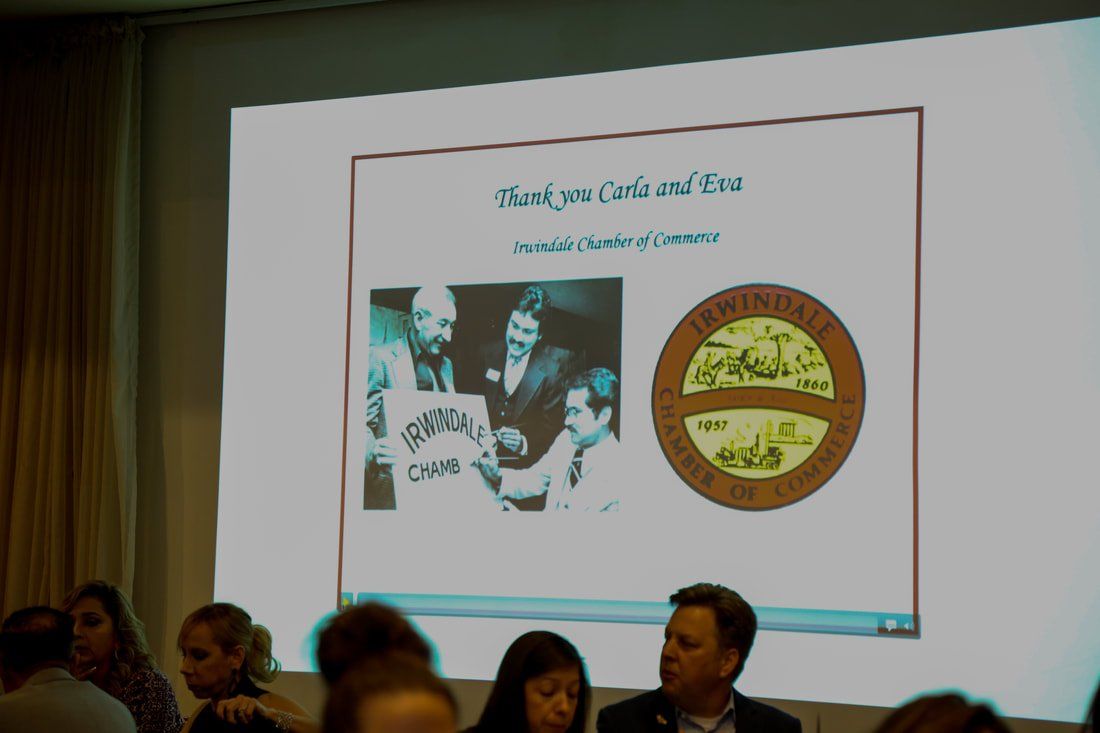 A group of people are sitting in front of a large screen with a picture on it