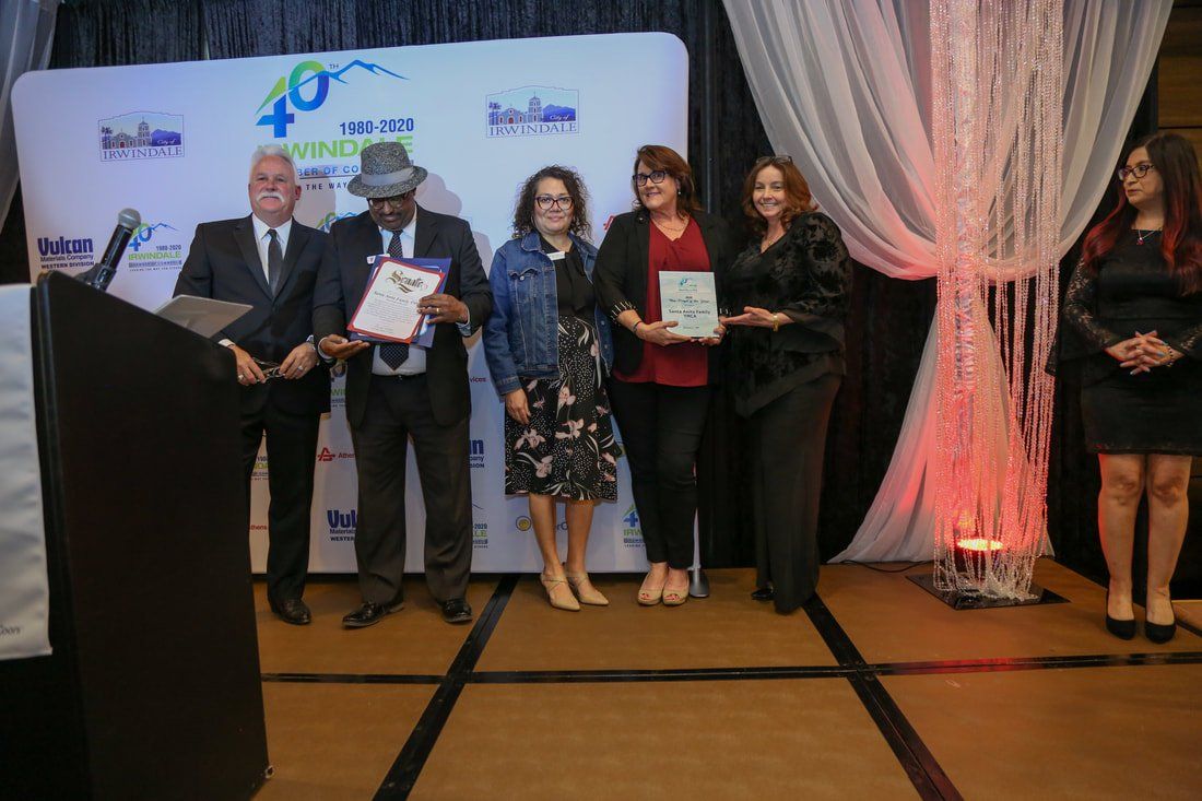A group of people are standing on a stage holding awards.