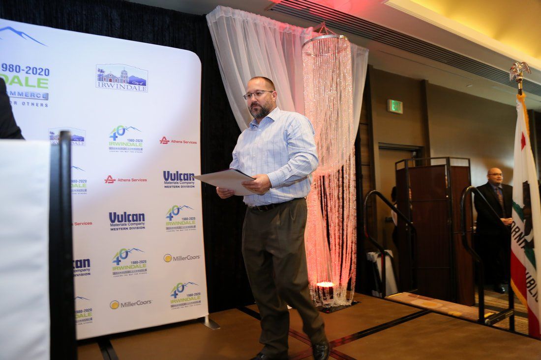 A man is standing on a stage holding a piece of paper.
