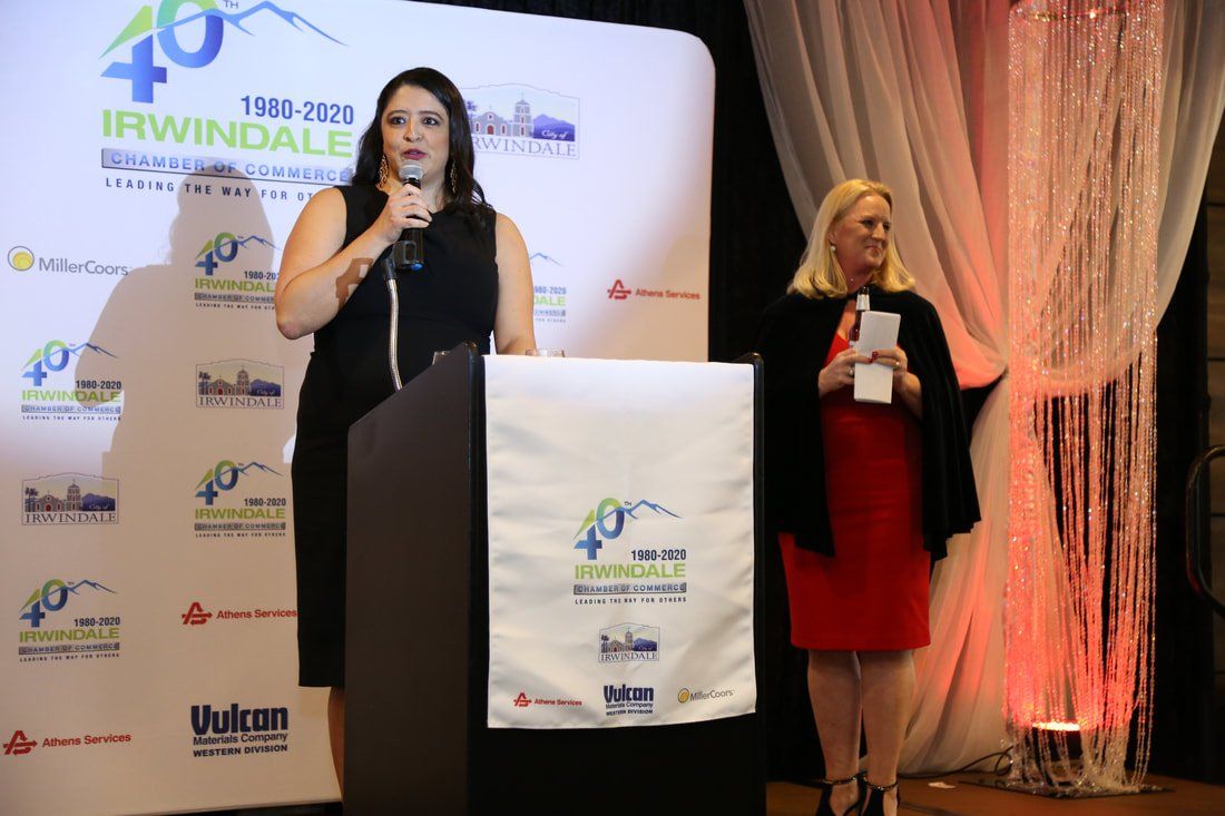 Two women are standing at a podium giving a speech.