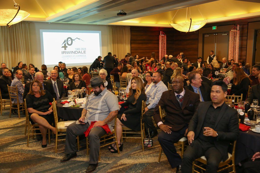 A large group of people are sitting at tables in a large room.