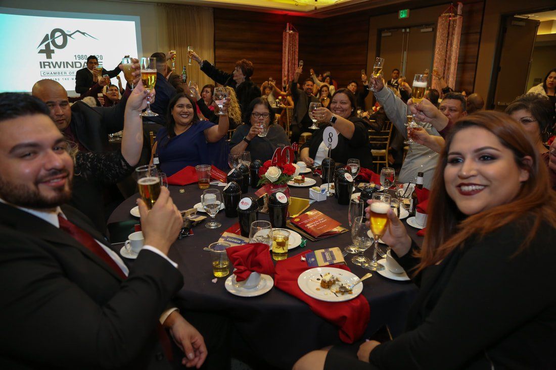 A group of people are sitting at a table toasting with champagne.