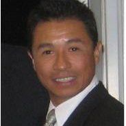 A woman wearing glasses and a white shirt is smiling in a black and white photo.