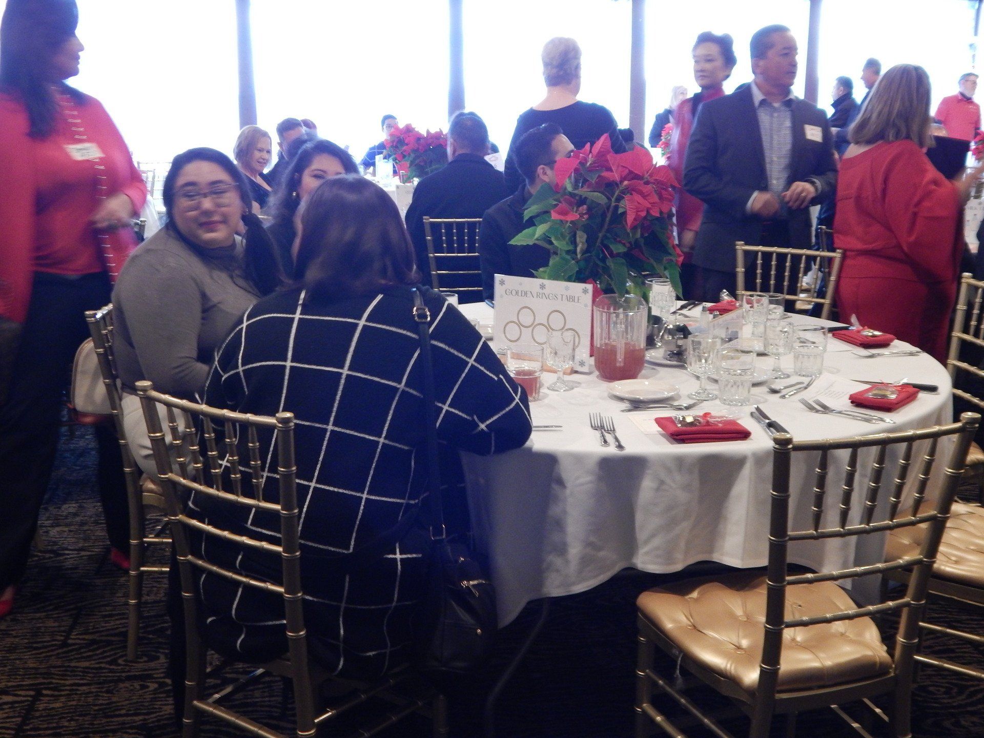 A group of people are sitting around a table with a sign that says ' dinner ' on it
