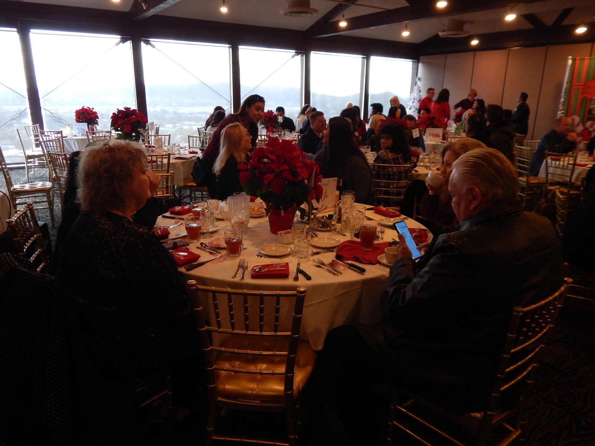 A group of people are sitting at tables in a large room.