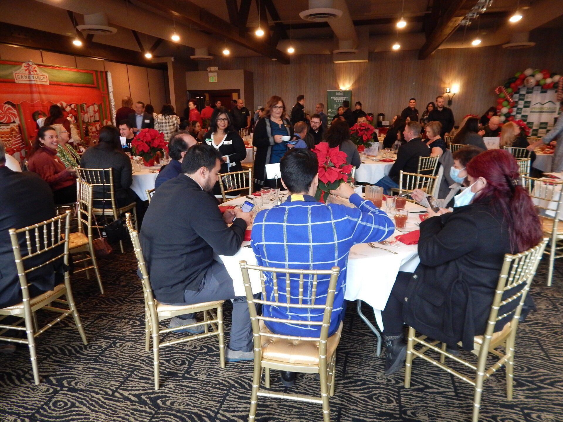 A large group of people are sitting at tables in a large room.
