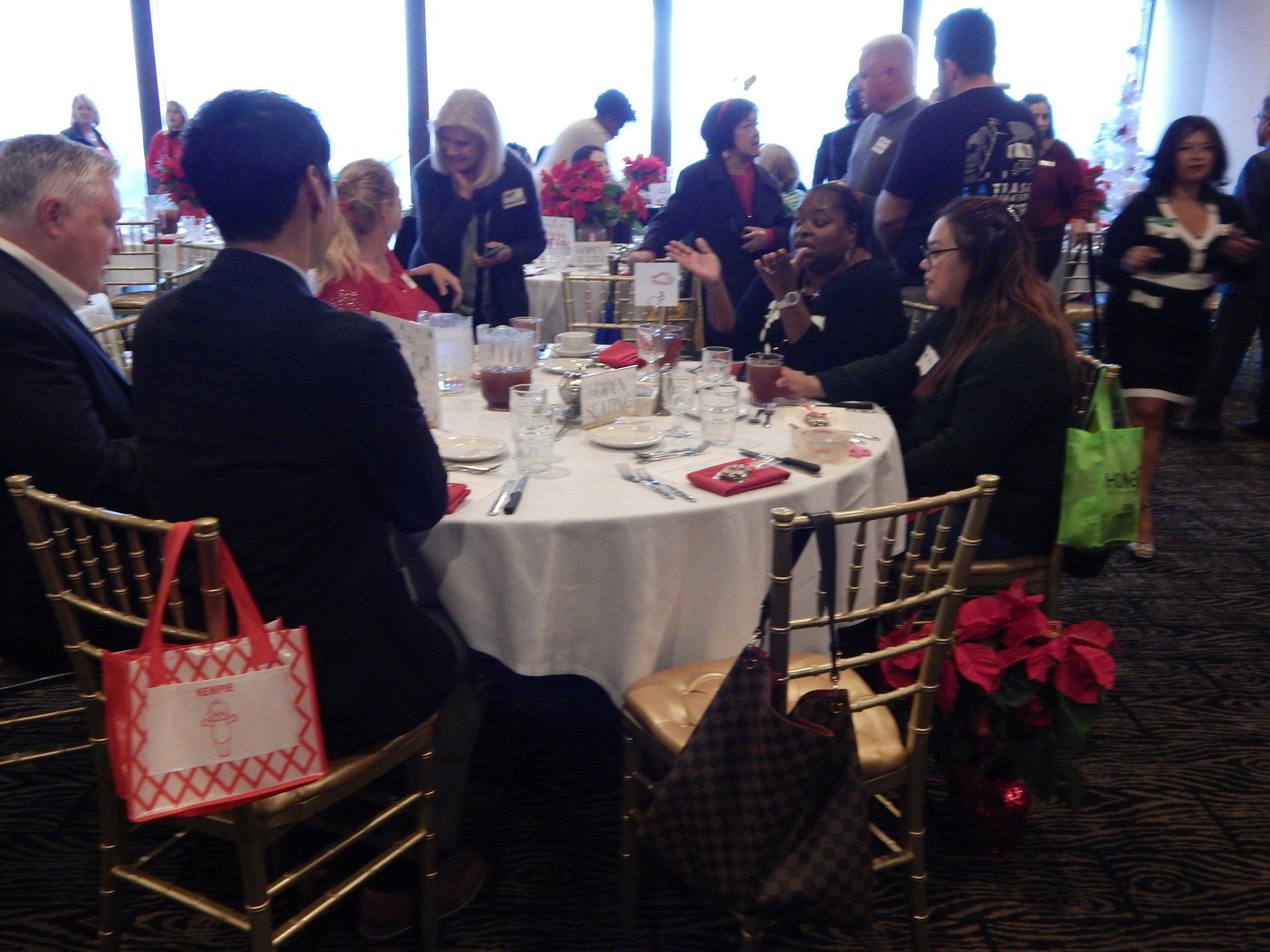 A group of people sitting around a table with a bag that says ' i love you ' on it