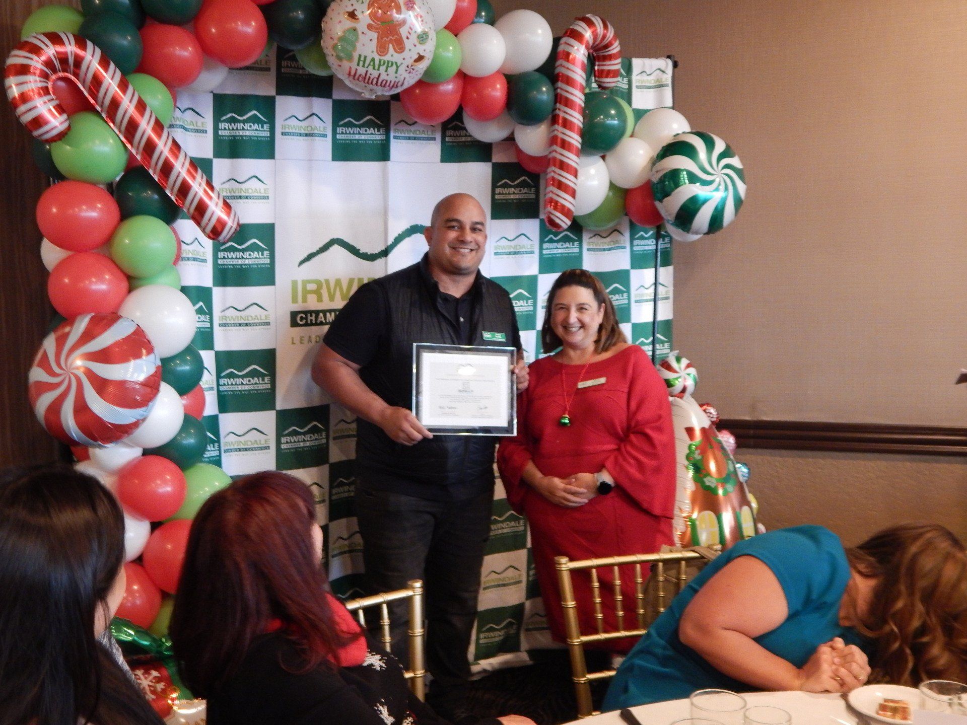 A man is holding a certificate in front of a group of people.
