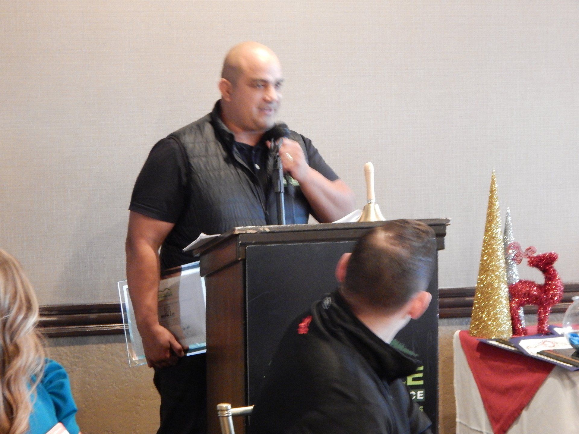 A man stands at a podium speaking into a microphone